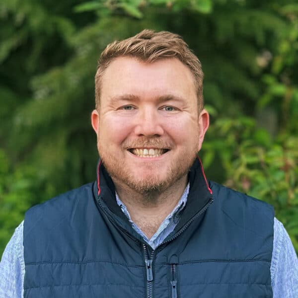 Matthew Wellington, Brand, Marketing and Proposals Manager at Create Consulting Engineers, smiling outdoors against green foliage background.