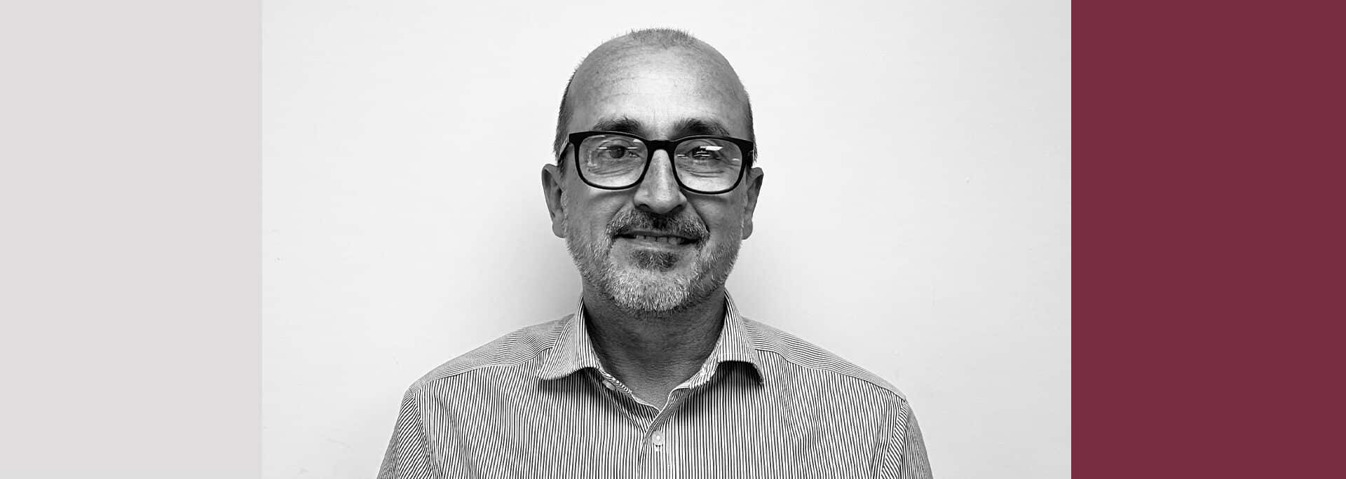 Portrait of Rob Brusselen, Principal Civil Engineer at Create Consulting Engineers, wearing glasses and striped shirt against neutral background.