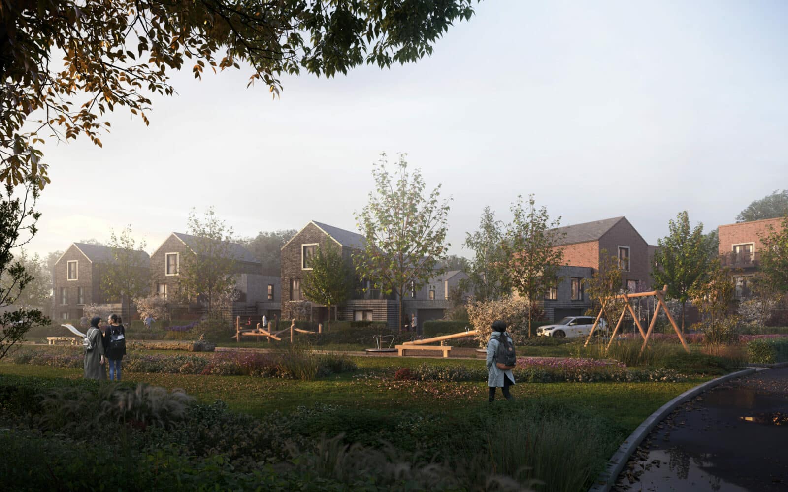 Newbury Farm final phase residential development showing brick houses, landscaped grounds with play equipment, and mature trees in Cambridge.