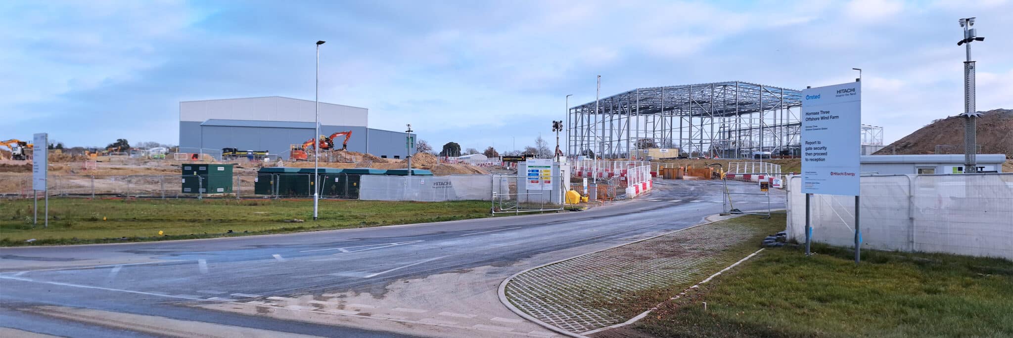 Hornsea 3 Offshore Wind Farm infrastructure site showing construction facilities, steel framework structures, and industrial buildings under development.
