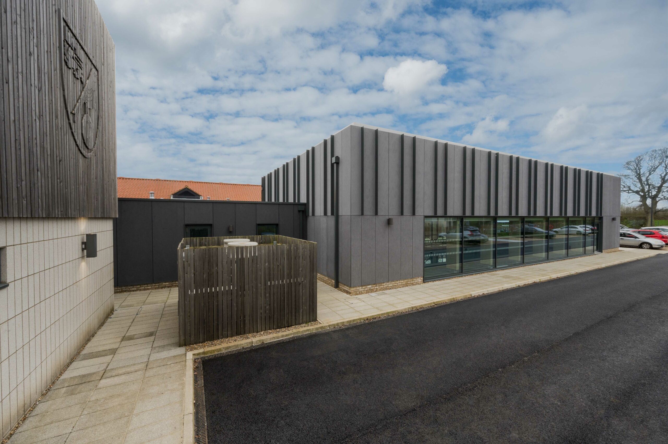 Modern grey corrugated metal building with extensive glazing, the Norwich City Football Club Recovery Hub designed by LSI Architects.