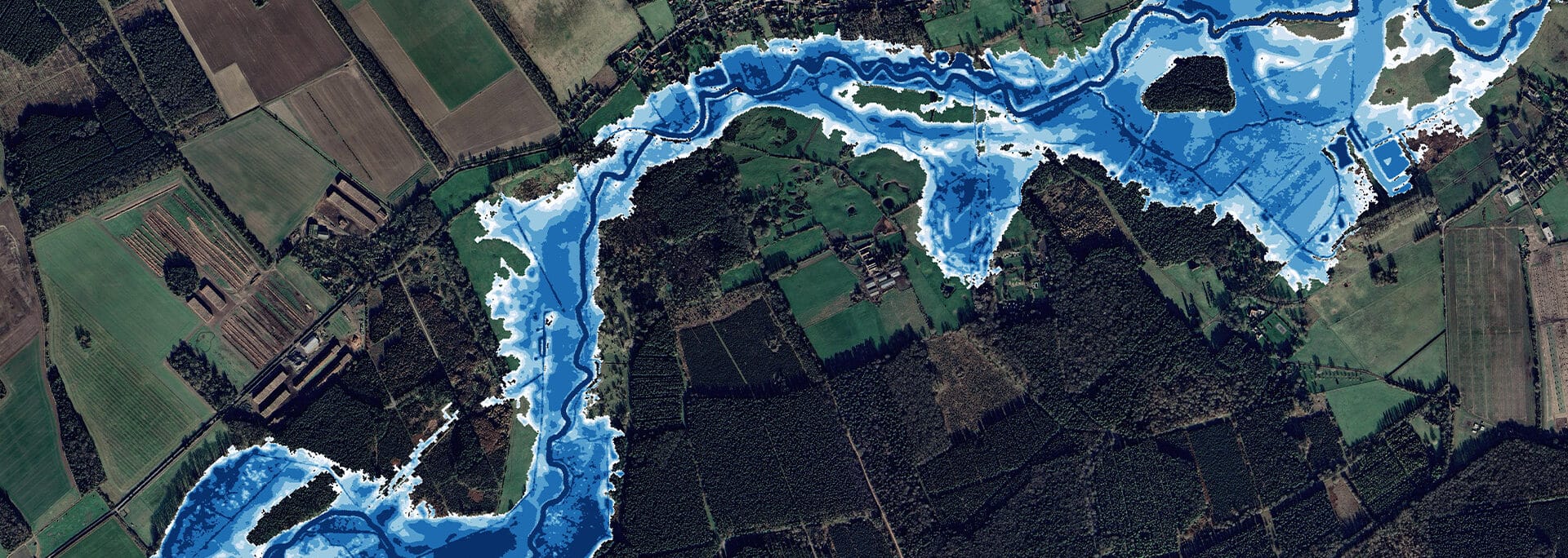 Aerial view of river flood extent mapping showing blue flood zones overlaid on agricultural land and forest, demonstrating flood risk assessment for planning purposes.