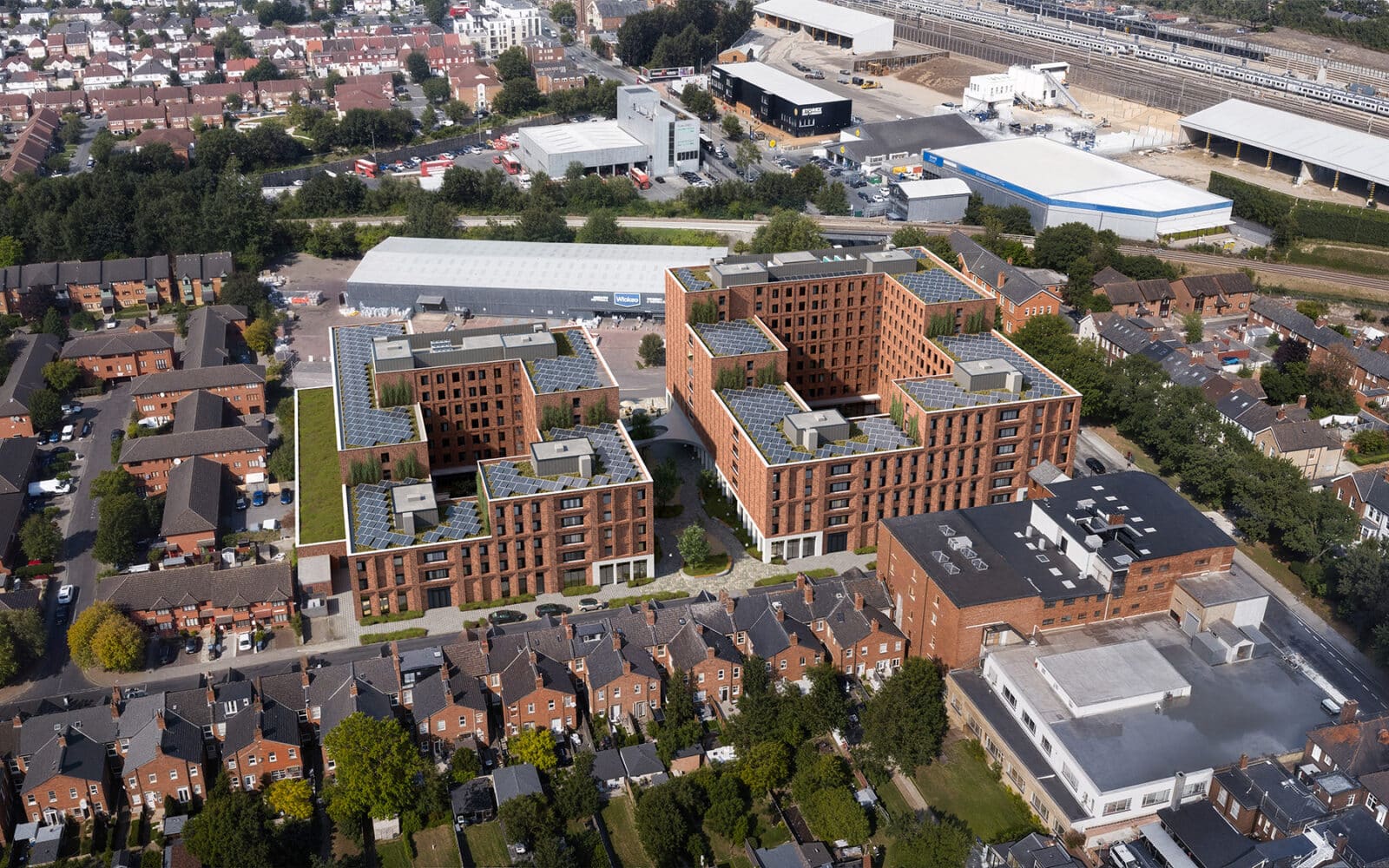 Aerial view of Stoll Square, 317 Cricklewood Broadway, London showing modern residential buildings with brick facades and solar panels.