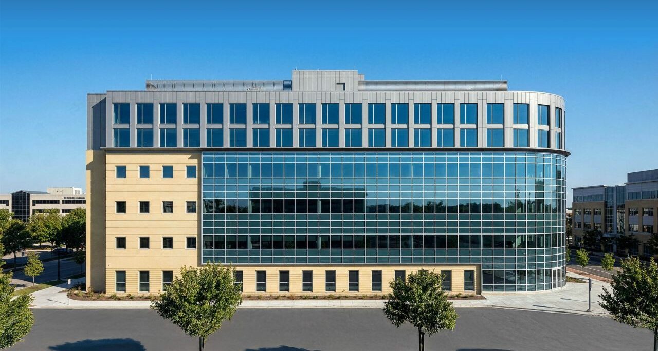 Modern mixed-use building at Thames Valley Park, Reading, featuring curved glass façade, stone base, and upper residential levels for apartment development.