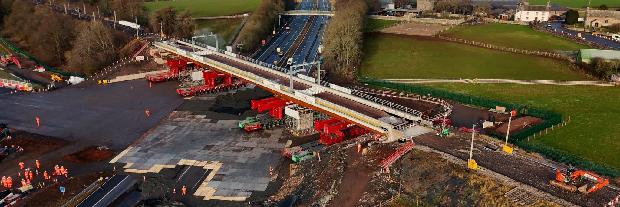 New Clifton railway bridge in final position relinking West Coast Main Line near Penrith, spanning M6 motorway during construction.
