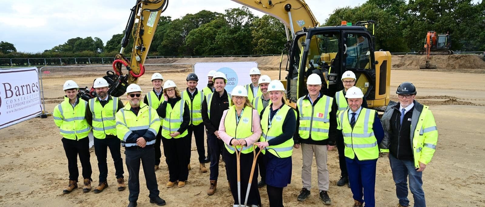 Ground breaking ceremony for St Elizabeth Hospice in Gorleston with construction teams and staff in high-visibility wear.