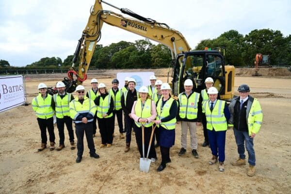 Ground breaking ceremony for St Elizabeth Hospice in Gorleston with construction teams and staff in high-visibility wear.